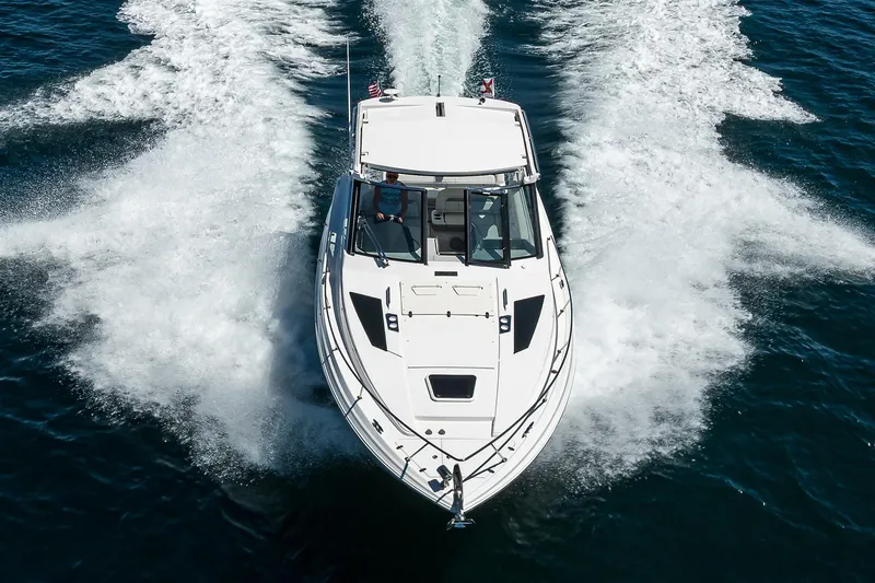Slide: The Image of 2020 Regal 35 Sport Coupe cruising on open water, creating dynamic wake patterns. - 49