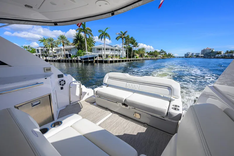 Slide: The Image of 2020 Regal 35 Sport Coupe cruising on a sunny waterfront with palm trees. - 6