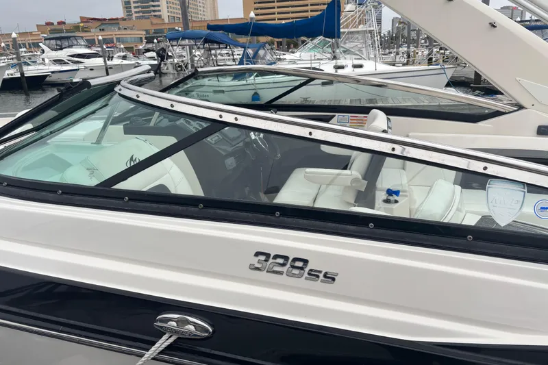 Slide: The Image of 2014 Monterey 328 Super Sport boat docked at marina, featuring sleek design and white interior. - 16