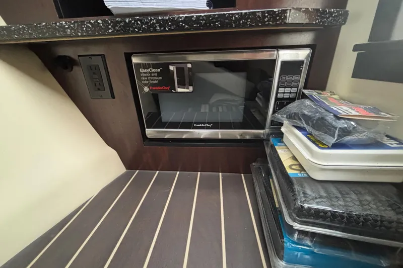 Slide: The Image of Microwave in 2014 Monterey 328 Super Sport boat interior with wood flooring and countertop. - 25