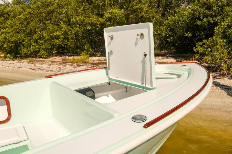 Slide: The Image of 2026 Willy Roberts 20 Bonefish boat with open storage compartment near shoreline. - 14