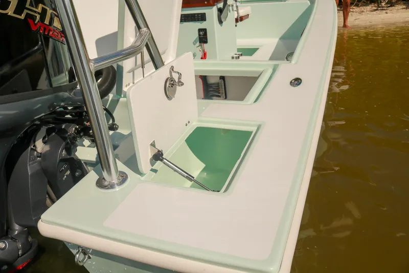 Slide: The Image of 2026 Willy Roberts 20 Bonefish boat with open storage compartments near shore. - 17