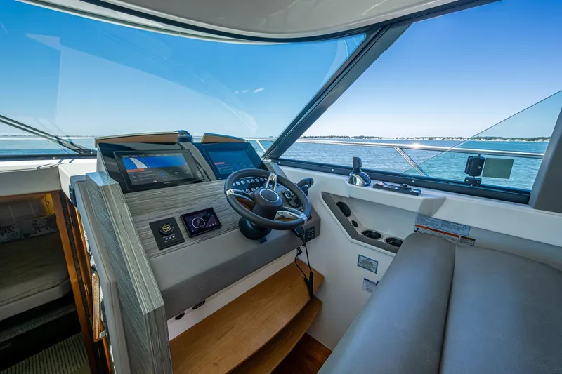 Slide: The Image of 2020 Tiara Yachts C44 Coupe helm with modern navigation systems and panoramic sea view. - 101