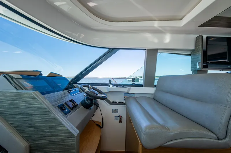 Slide: The Image of 2020 Tiara Yachts C44 Coupe interior with helm and seating, overlooking the ocean. - 102