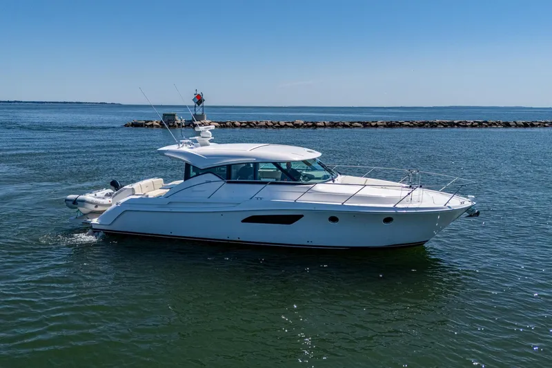 Slide: The Image of 2020 Tiara Yachts C44 Coupe cruising on open water under clear blue skies. - 11