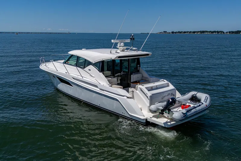 Slide: The Image of 2020 Tiara Yachts C44 Coupe cruising on open water, rear view. - 18
