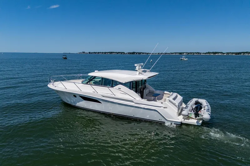 Slide: The Image of 2020 Tiara Yachts C44 Coupe cruising on open water under clear blue skies. - 19
