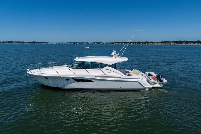 Slide: The Image of 2020 Tiara Yachts C44 Coupe cruising on open water under clear blue skies. - 21