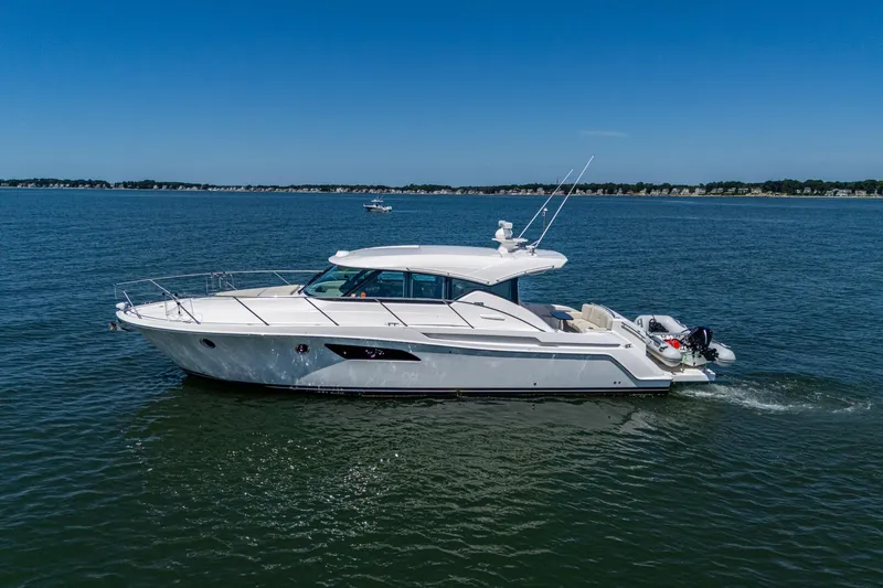 Slide: The Image of 2020 Tiara Yachts C44 Coupe cruising on open water under clear blue skies. - 22