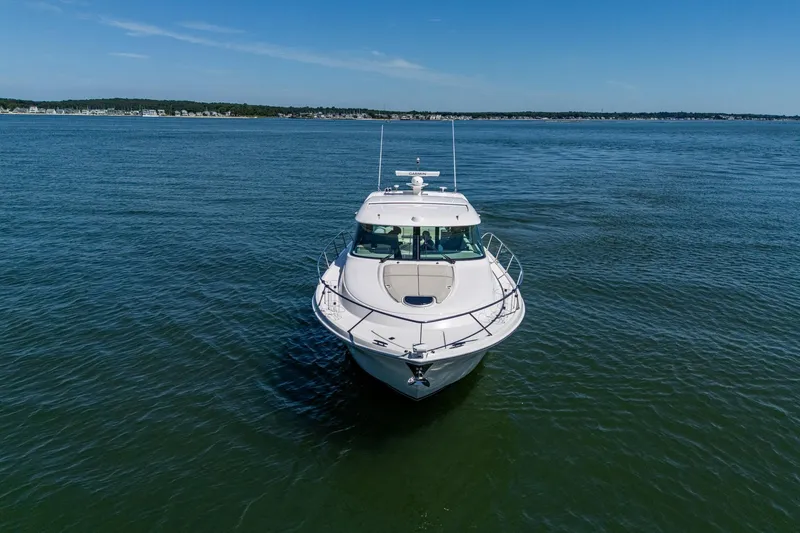 Slide: The Image of 2020 Tiara Yachts C44 Coupe cruising on open water under clear blue skies. - 24