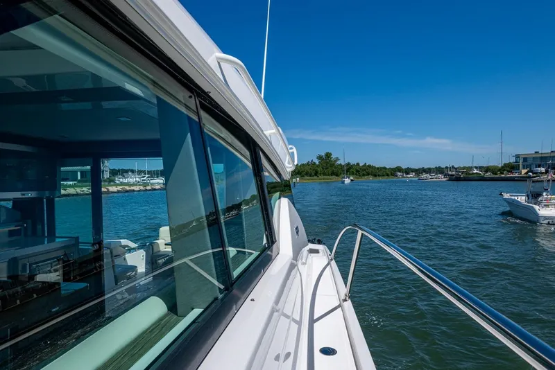 Slide: The Image of 2020 Tiara Yachts C44 Coupe cruising on a sunny day near a marina. - 31