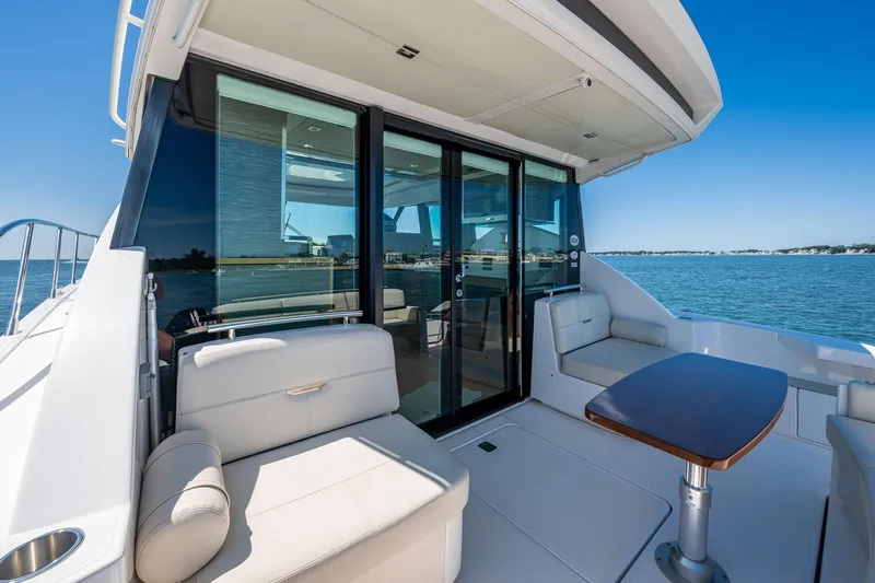 Slide: The Image of 2020 Tiara Yachts C44 Coupe, elegant deck with seating and table, ocean view. - 36