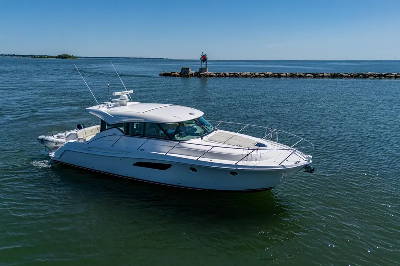 Slide: The Image of 2020 Tiara Yachts C44 Coupe cruising on calm waters under clear blue skies. - 5