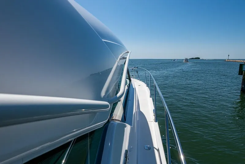 Slide: The Image of 2020 Tiara Yachts C44 Coupe cruising on open water under clear blue skies. - 6