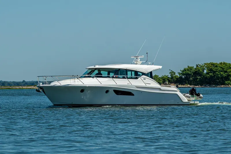 Slide: The Image of 2020 Tiara Yachts C44 Coupe cruising on calm waters, clear sky background. - 71