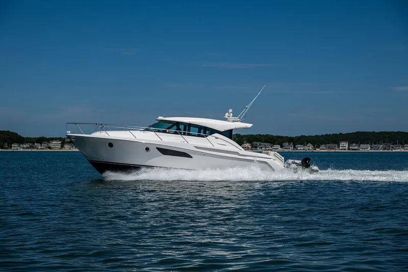 Slide: The Image of 2020 Tiara Yachts C44 Coupe cruising on open water under clear blue sky. - 75