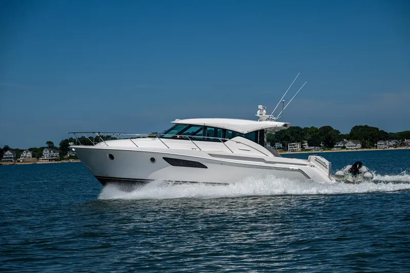 Slide: The Image of 2020 Tiara Yachts C44 Coupe cruising on a sunny day near the shoreline. - 76