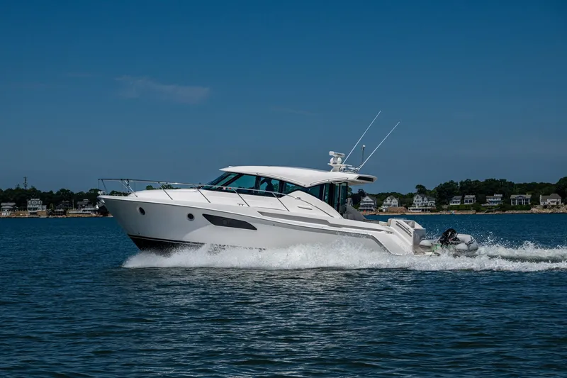 Slide: The Image of 2020 Tiara Yachts C44 Coupe cruising on a sunny day near coastal homes. - 77