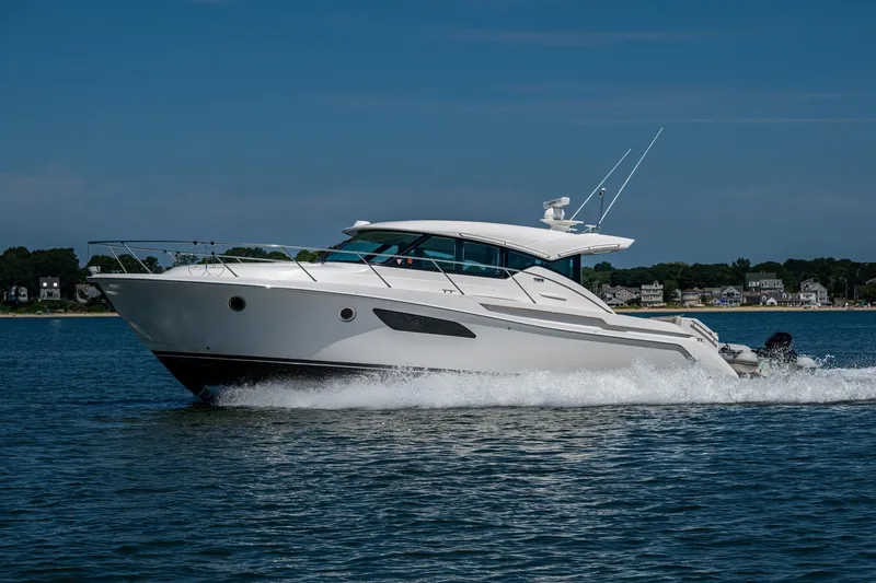 Slide: The Image of 2020 Tiara Yachts C44 Coupe cruising on water, showcasing sleek design and luxury. - 78