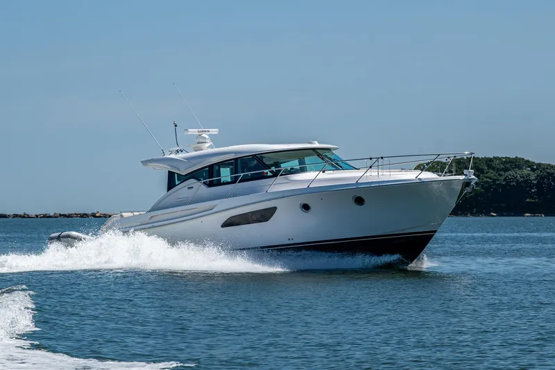 Slide: The Image of 2020 Tiara Yachts C44 Coupe cruising on open water, showcasing sleek design and performance. - 83