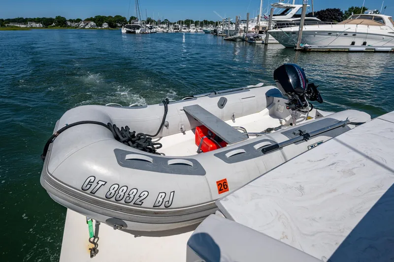 Slide: The Image of Inflatable dinghy with outboard motor on Tiara Yachts C44 Coupe, 2020 model, docked in marina. - 89