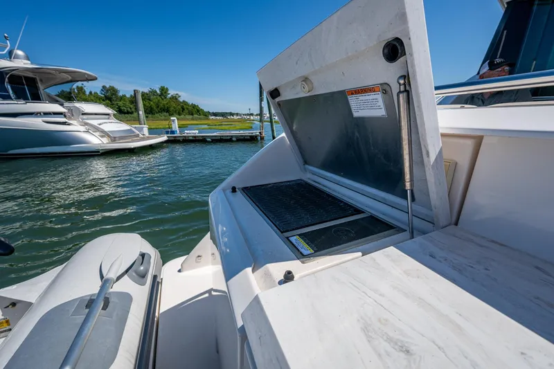 Slide: The Image of 2020 Tiara Yachts C44 Coupe with open grill on deck, docked by water. - 90