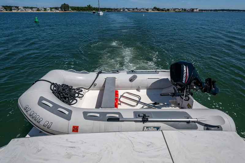 Slide: The Image of 2020 Tiara Yachts C44 Coupe with inflatable boat and Mercury motor on water. - 91