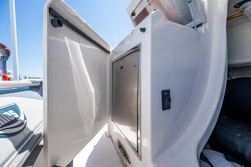 Slide: The Image of 2020 Tiara Yachts C44 Coupe storage compartment with open door, showcasing sleek design. - 92
