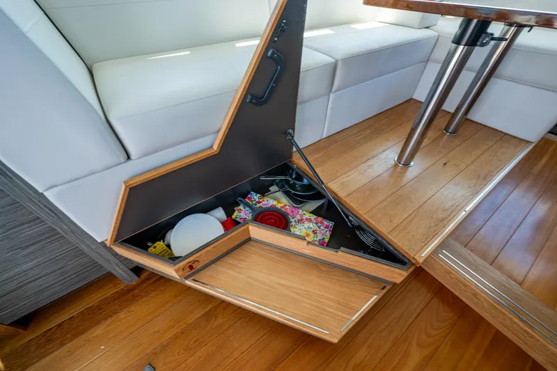 Slide: The Image of 2020 Tiara Yachts C44 Coupe interior storage compartment with wooden flooring and white seating. - 98