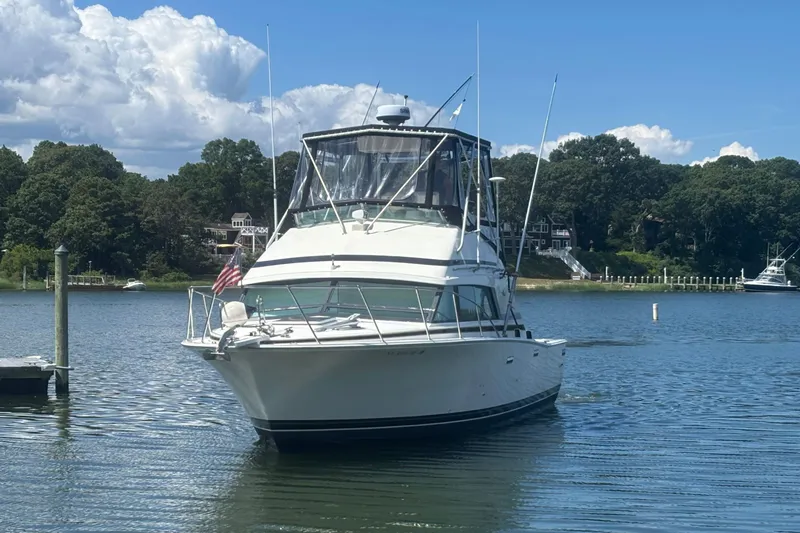 Slide: The Image of 1998 Bertram 33 Convertible Sport Fisherman boat docked on a serene lake. - 1