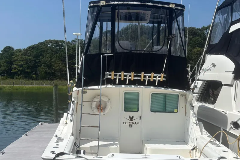 Slide: The Image of 1998 Bertram 33 Convertible Sport Fisherman docked, rear view with fishing rod holders. - 4