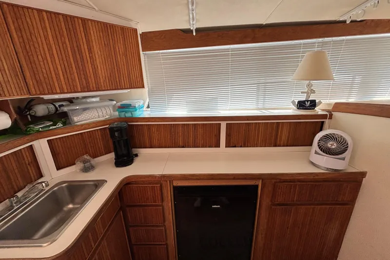 Slide: The Image of 1998 Bertram 33 Convertible Sport Fisherman interior kitchen with wood cabinets and appliances. - 6