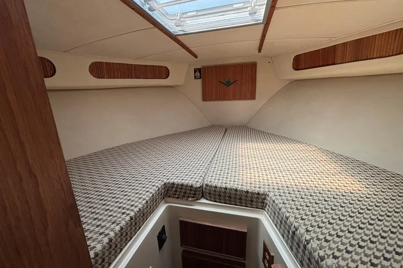 Slide: The Image of 1998 Bertram 33 Convertible Sport Fisherman cabin interior with patterned bedding and skylight. - 8