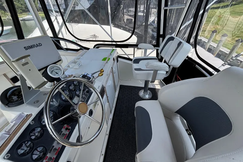 Slide: The Image of 1998 Bertram 33 Convertible Sport Fisherman cockpit with steering wheel and navigation equipment. - 9