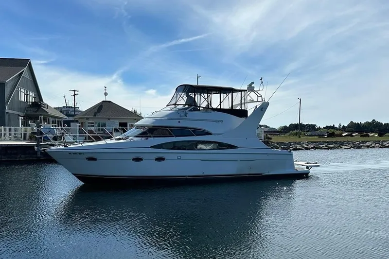 Slide: The Image of 2002 Carver 410 Sport Sedan yacht docked in a serene marina setting. - 0
