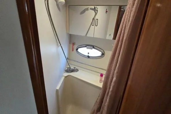 Slide: The Image of 2002 Carver 410 Sport Sedan bathroom with shower, mirror, and porthole window. - 12