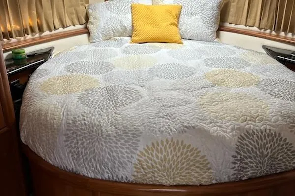 Slide: The Image of Cozy bedroom in 2002 Carver 410 Sport Sedan with patterned bedding and yellow accent pillow. - 7
