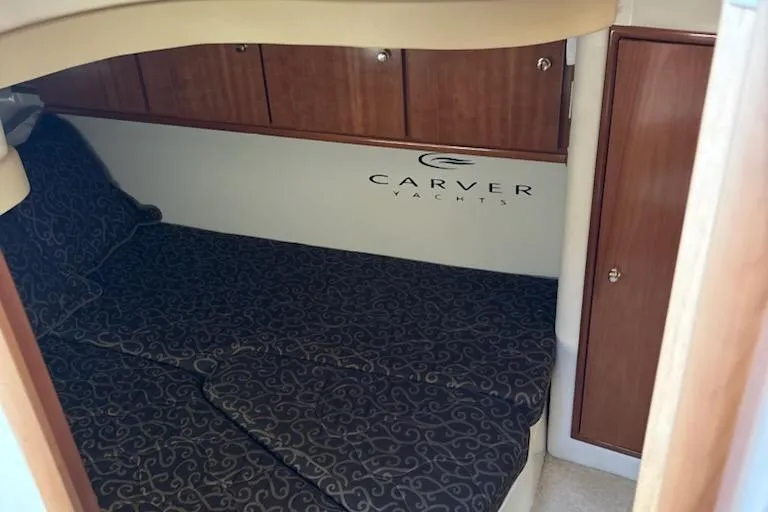 Slide: The Image of 2002 Carver 410 Sport Sedan cabin with elegant wood cabinetry and patterned bedding. - 8