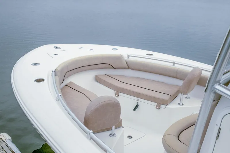 Slide: The Image of 2019 Sportsman Open 212 Center Console boat with cushioned seating, docked on calm water. - 12