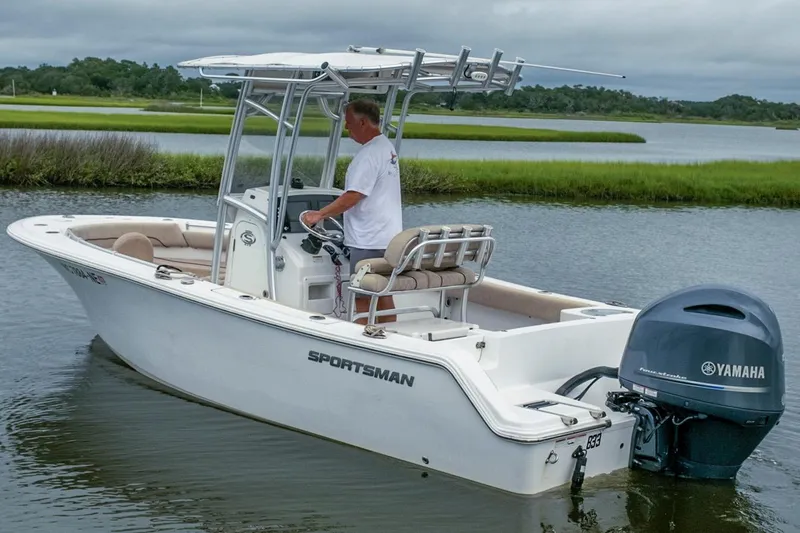 Slide: The Image of 2019 Sportsman Open 212 Center Console boat on calm water with Yamaha outboard motor. - 4