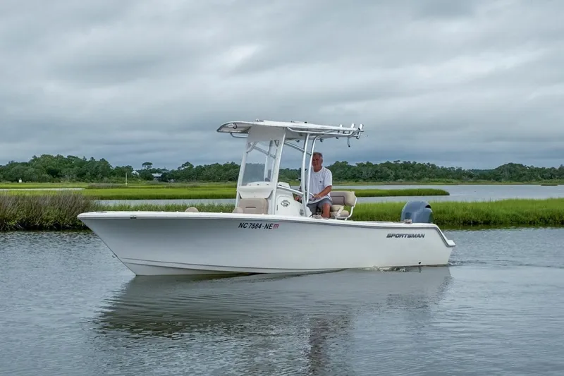 Slide: The Image of 2019 Sportsman Open 212 Center Console boat on calm water with lush greenery background. - 5