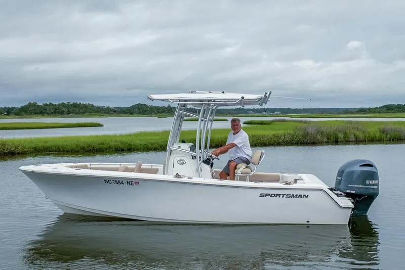 Slide: The Image of 2019 Sportsman Open 212 Center Console boat on calm water with lush green background. - 6