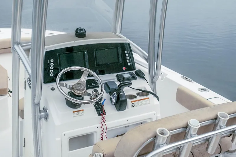 Slide: The Image of 2019 Sportsman Open 212 Center Console boat dashboard with steering wheel and navigation screens. - 9