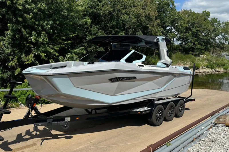 The Image of 2026 Nautique Super Air Nautique G23 Paragon boat on trailer, parked near water. - 0