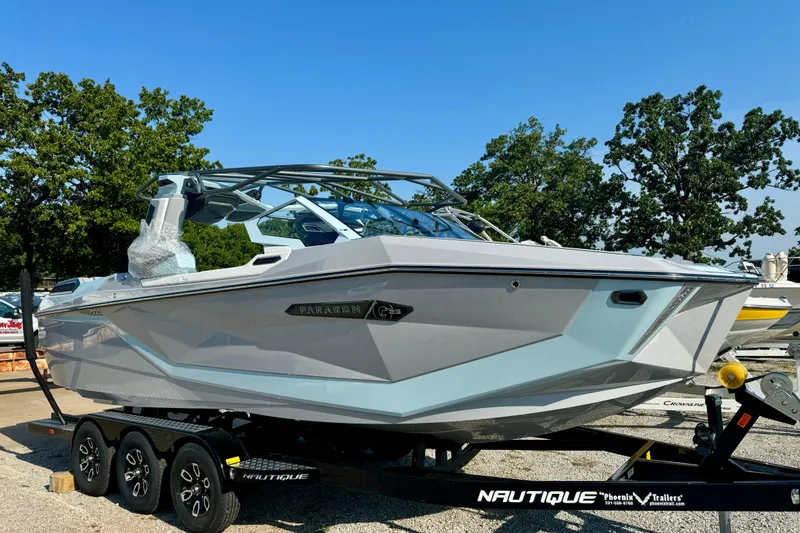 Slide: The Image of 2026 Nautique Super Air Nautique G23 Paragon boat on trailer, surrounded by trees. - 5