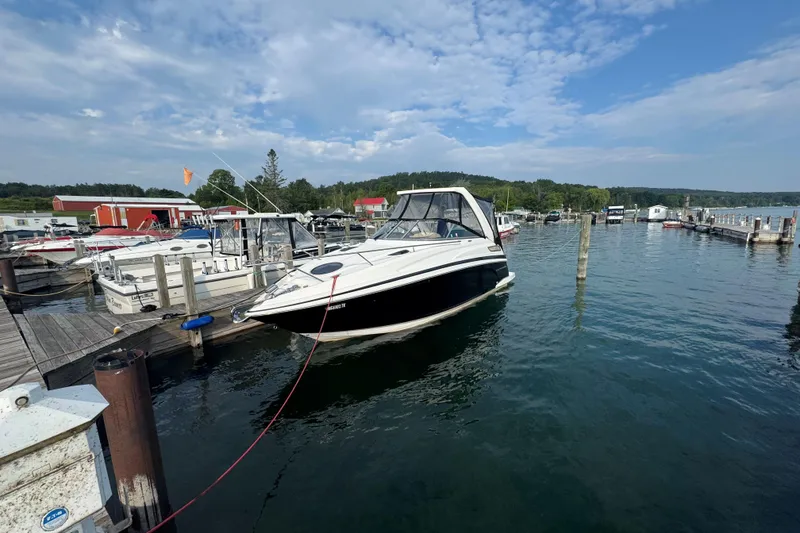 Slide: The Image of 2012 Regal 28 Express boat docked at a marina under a partly cloudy sky. - 1