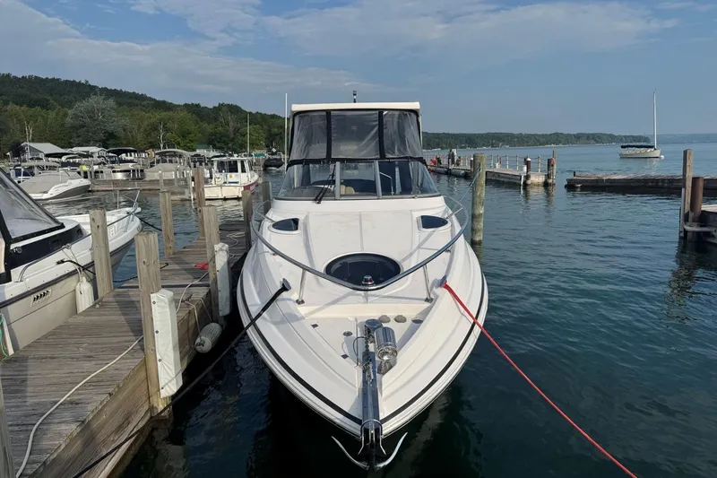 Slide: The Image of 2012 Regal 28 Express boat docked at a marina with scenic lake view. - 2
