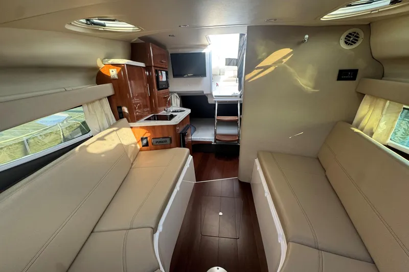 Slide: The Image of Interior of 2012 Regal 28 Express boat with beige seating and wooden cabinetry. - 20