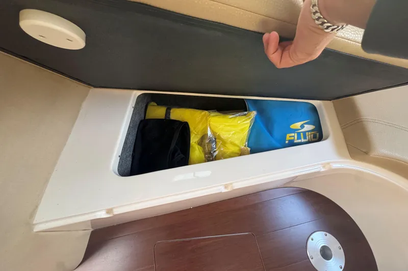 Slide: The Image of Storage compartment in a 2012 Regal 28 Express boat, containing life jackets and gear. - 22