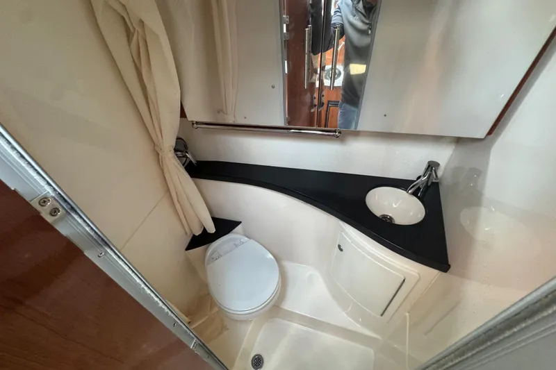 Slide: The Image of 2012 Regal 28 Express bathroom with sink, toilet, and mirror in compact space. - 28